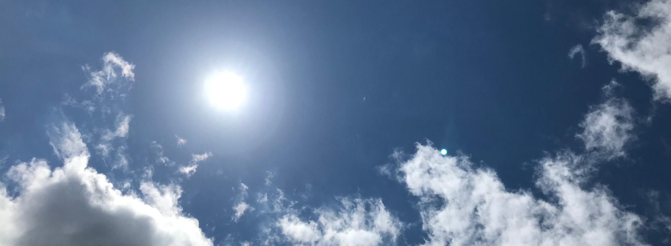 Sonne am leicht bewölkten Himmel