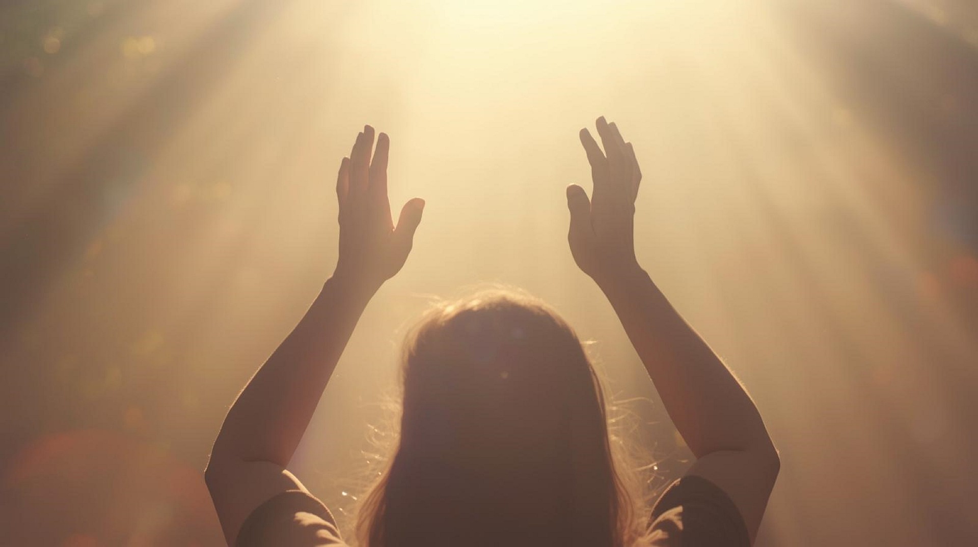 Hände, die einem von oben kommenden, goldenen Licht entgegengestreckt werden